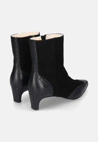 Zwarte enkellaarzen van een combinatie van suede en leer, met een spitse neus, blokhak en ingewikkelde stiksels langs de zijkant.