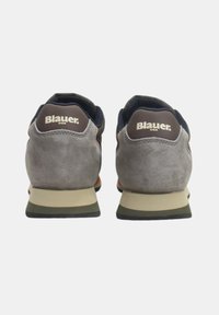 Chaussures de sport en suède gris avec une tige en mesh bleu marine foncé, une semelle beige et des accents bruns, arborant le logo "Blauer USA" sur le talon.