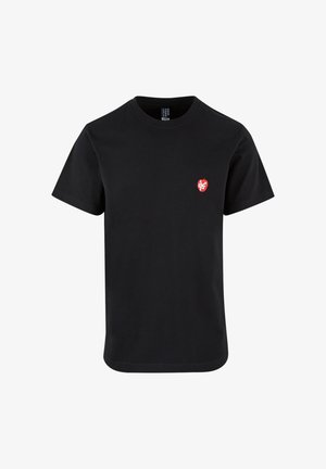T-shirt di cotone nero con maniche corte, scollo rotondo e un piccolo emblema grafico rosso sull'area sinistra del petto. Design semplice.