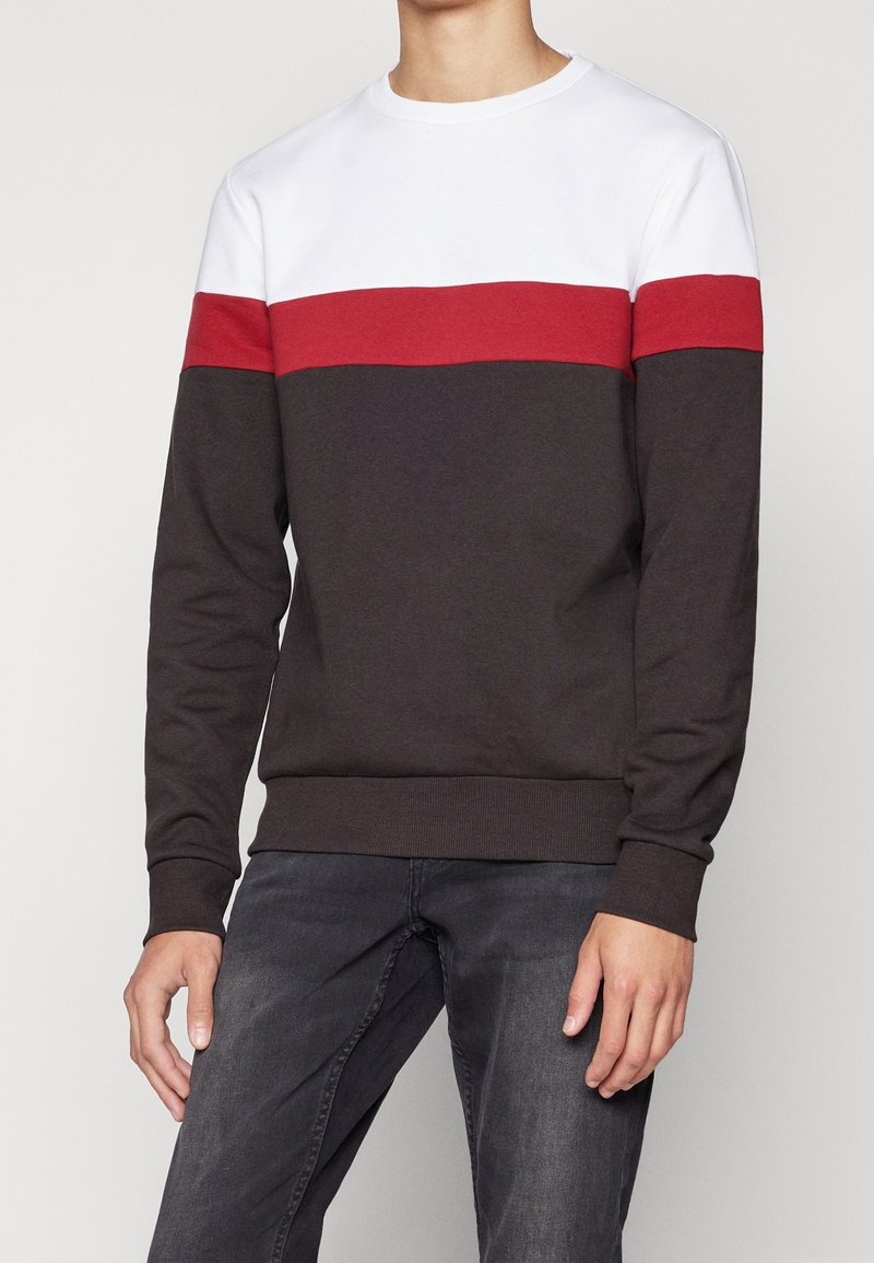 Bomulds-sweatshirt med hvid top, en rød vandret stribe samt mørkegrå ærmer og krop. Ribstrikkede manchetter og kant for pasform.