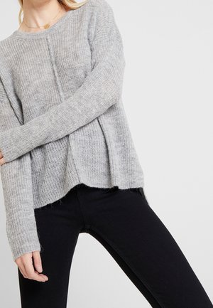 Maglione lavorato a maglia grigio chiaro con una vestibilità rilassata. Presenta maniche lunghe, scollatura rotonda e leggere fessure laterali all'orlo.