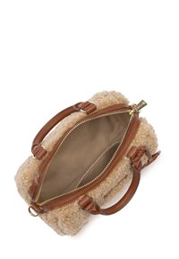 Tan schapenvacht handtas met bruine leren handvatten en afwerkingen. Ritsluiting onthult een beige binnenvoering. Compacte, ronde vorm.