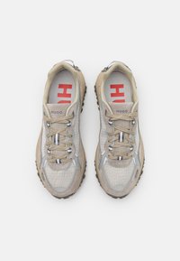 Scarpe sportive beige con una tomaia in rete, accenti in suede testurizzato, lacci rotondi e solette con logo rosso. Presenta una suola robusta per la trazione.