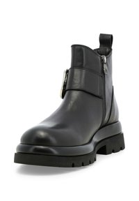 Stivale alla caviglia in pelle nera con punta rotonda, zip laterale e dettaglio con cinturino regolabile. Suola in gomma spessa con un motivo di battistrada.