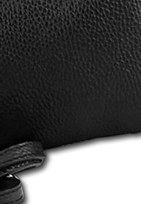 Zwarte leren tas met een textuurafwerking, voorzien van een gladde band en een ronde vorm. Het materiaal vertoont natuurlijke nerfdetails.
