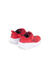 Scarpe da ginnastica rosse con parte superiore in rete, cinturino in velcro e suola spessa bianca. Presentano un logo sul lato e un anello sul tallone per facilitarne l'indossamento.