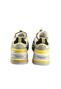 Rumene in sivo usnjeni superge z robustnim dizajnom, ki imajo črne poudarke, teksturiran podplat in blagovno znamko na zadnjem in petnem delu.