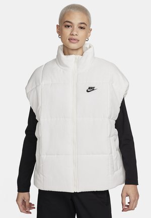 Witte puffer vest met een hoge kraag, ritssluitingen en zwart Nike-logo op de borst. Gemaakt van gewatteerde stof, met korte mouwen.