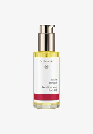 Bouteille en verre transparent avec un bouchon-pompe en métal argenté. Huile corporelle jaune à l'intérieur, étiquetée « Huile corporelle nourrissante à la rose » avec un accent rouge à la base.