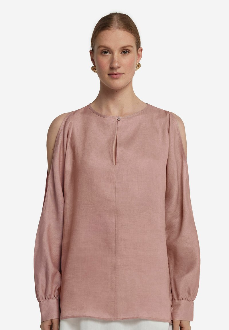Ljusrosa linneskjorta med långa ärmar, kallaxelskärningar, knäppning och en smal nyckelhålöppning vid halsen.