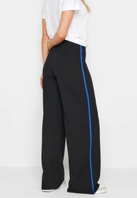 Zwarte wijde broek met een blauwe zijstreep; gemaakt van een soepele stof; heeft een hoge taille en een minimalistisch ontwerp.