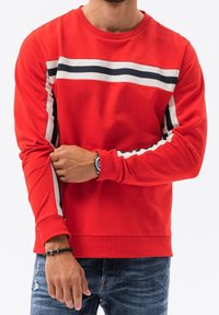 Sudadera roja de manga larga, con rayas horizontales en blanco y negro en el pecho, puños acanalados y textura suave.