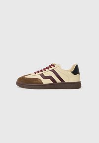 Adidași cu un corp din piele crem, cu accente din suede maro și burgund, talpă maro închis și șireturi burgund. Design cu limbă rotundă.