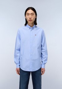 Chemise boutonnée rayée bleu clair avec col, manches longues et ourlet arrondi. Petit détail de logo sur la poitrine. Coupe classique.