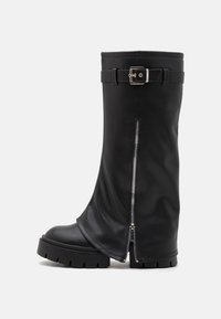 Bota negra de cuero hasta la rodilla con suela gruesa, cremallera lateral y un acento de cinturón en la parte superior. Textura suave con acabado mate.