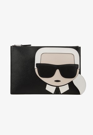 Pochette noire avec un visage graphique présentant des cheveux blancs attachés, des lunettes de soleil noires et un col de chemise blanc. Fermeture éclair sur le bord supérieur.