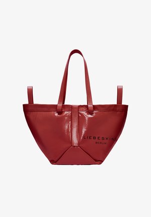 Czerwona błyszcząca torba tote z dwoma długimi uchwytami, z charakterystyczną trójkątną podstawą i wytłoczonym logo marki "LIEBESKIND BERLIN" z przodu.