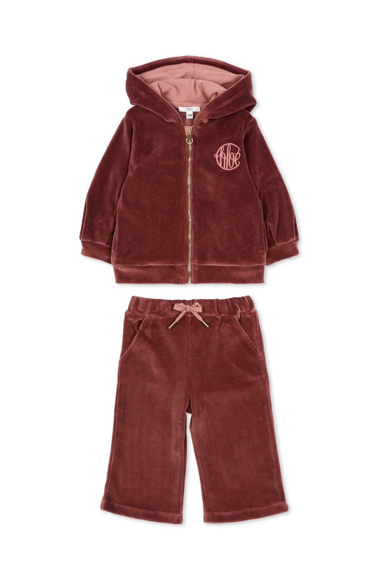 Bordowy welurowy dres dla dzieci, zawierający zapinaną na zamek kurtkę z kapturem i logo oraz pasujące spodnie z elastycznym pasem i sznurkiem.