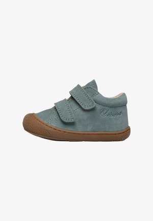 Scarpa di suede azzurro chiaro con due cinturini in velcro regolabili, suola in gomma, punta rotonda e un accento in gomma texturizzata color tan sulla punta.