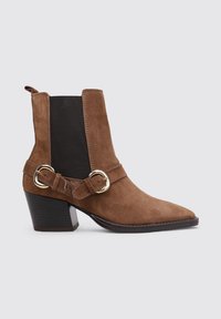 Bottines en suede marron avec un bout pointu, des côtés élastiques noirs et une sangle décorative avec une quincaillerie dorée. Design avec un talon épais.