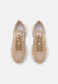 Sneaker beige con una parte superiore testurizzata realizzata in materiali mesh e suede, punta rotonda e suola in gomma bianca con battistrada visibile.
