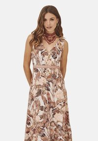 Vestido maxi floral en suaves tonos rosa y marrón. Presenta un diseño envolvente con escote en V, tirantes anchos y cintura ajustada. Patrones de hojas intrincados.