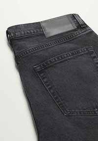 Mustat denimfarkut, joissa on takatasku, teksturoitu pinta ja sileä musta nahkainen merkki vyötäröllä.