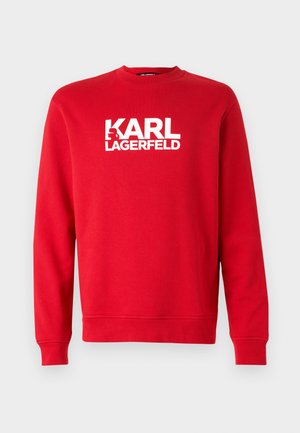 Rød sweatshirt i bomuld med langeærmer. Har en rund halsudskæring og iøjnefaldende hvid tekst "KARL LAGERFELD" foran. Enkel design.