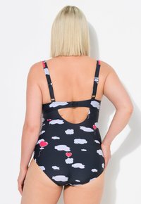 Maillot de bain une pièce bleu marine avec des motifs de nuages et de ballons en cœur rouge. Bretelles ajustables et dos ouvert, avec une fermeture à crochet.