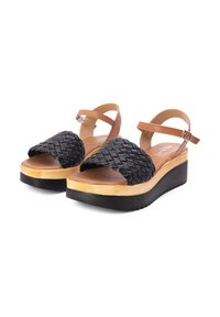 Sandali neri intrecciati con cinturini in pelle marrone, una piattaforma in legno chiaro e una suola in gomma nera. Fibbia regolabile per una vestibilità sicura.