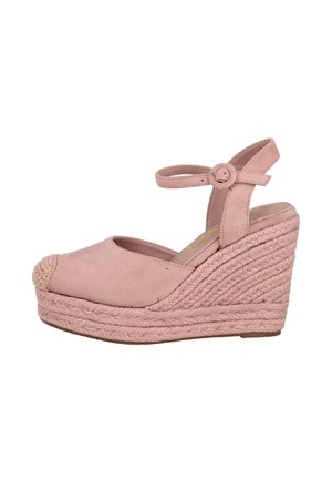 Zapato de tacón cuña de ante rosa con tira en el tobillo. Las características notables incluyen una punta redonda y detalles de yute tejido en la plataforma.