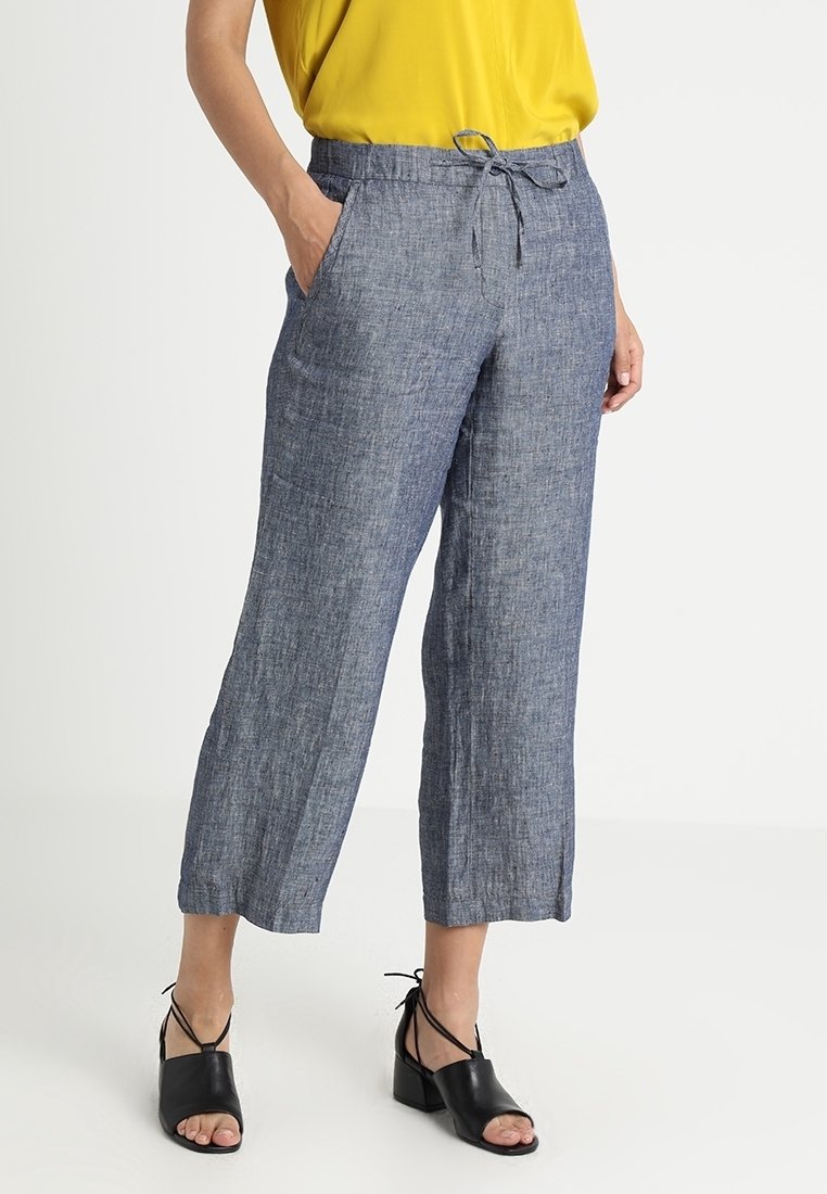 Pantaloni in lino leggeri e blu con una vestibilità rilassata, vita con cordino e tasche laterali, caratterizzati da una leggera texture e gambe wide.