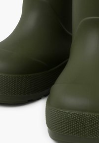 Stivali da pioggia in gomma verde con suola testurizzata, design arrotondato e finitura liscia. Gli stivali presentano una silhouette a profilo basso.