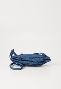 Borsa in denim blu con profilo slim, tracolla regolabile e superficie testurizzata. Presenta un motivo astratto sottile e una chiusura con zip.