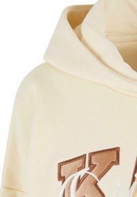 Felpa con cappuccio color crema caratterizzata da un tessuto testurizzato, vestibilità oversize e un prominente logo ricamato marrone sul davanti.