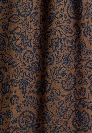 Brunt stof med indviklede mørkeblå blomster- og paisleymønstre, der viser en blød, struktureret overflade med blide folder.