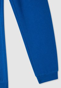 Niebieskie dresy wykonane z miękkiej mieszanki bawełny, z elastycznymi mankietami i gładką strukturą dla wygody.