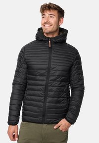 Black puffy jacket with a hood, featuring a quilted design, zipper front, and ribbed accents on shoulders, made from lightweight fabric.