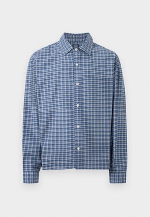 Modrá a biela károvaná košeľa s dlhým rukávom, zapínaná na gombíky, s golierom a predným vreckom na jednofarebnom svetlom pozadí.