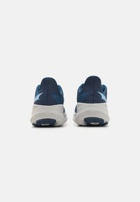 Sports shoes with a navy blue fabric upper, textured heel support, light blue accents, and a white rubber sole with a patterned tread.