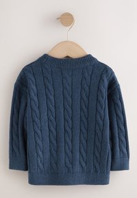 Marineblauwe gebreide trui met een gestructureerd kabelpatroon, ronde hals en geribbelde boorden en zoom, hangend aan een houten hanger tegen een lichte achtergrond.