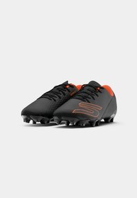 Crampons de football noirs avec une surface texturée, comportant des accents orange vif sur le col et le logo, ainsi que des crampons noirs pour une meilleure traction.