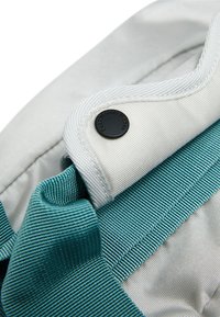 Gray fabric with a smooth texture features a teal accent component, secured by a black snap button on the edge, enhancing its design.