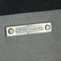 Prodotto in tessuto grigio con un'etichetta metallica incisa con "MARGELISCH", accentuata da due rivetti circolari. La texture è tessuta e resistente.