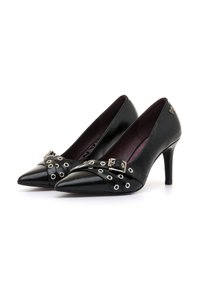 Schwarze Leder-Pumps mit hohen Absätzen und spitzer Zehenform, verziert mit silbernen Ösenriemen und Schnallendetail, sowie einer dunkelburgunderfarbenen Innenauskleidung.