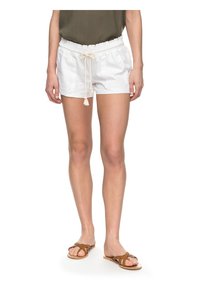 White lightweight shorts with an elastic waistband and drawstring, featuring two side pockets. Paired with brown flat sandals.