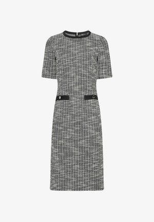 Korte mouw jurk in een gestructureerde zwart-witte stof, met een getailleerd silhouet, twee voorzakken met zwarte accenten en een ronde halslijn.