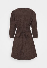 Robe marron foncé longueur genou avec manches longues, motifs découpés complexes et ceinture nouée à la taille, vue de dos sur fond blanc.
