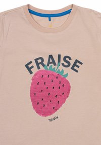 Šviesiai smėlinė medvilninė marškinėliai su dideliu rožiniu braškės piešiniu, žaliais lapais, juodomis sėklomis ir žodžiu "FRAISE" viršuje.