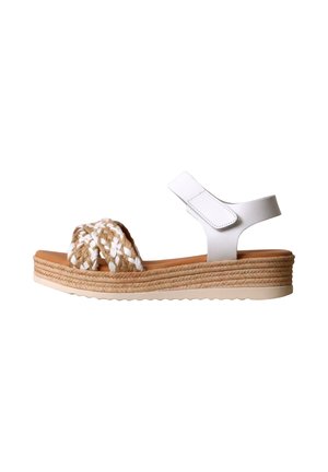 Sandalia blanca con tira en el tobillo, tiras delanteras trenzadas en beige y blanco, y suela plataforma texturizada.